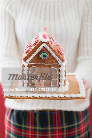 Woman holding gingerbread house