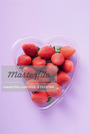 Fresh strawberries in heart-shaped plastic container
