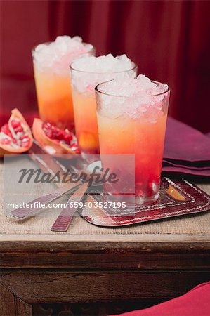 Three fruity drinks with orange and pomegranate