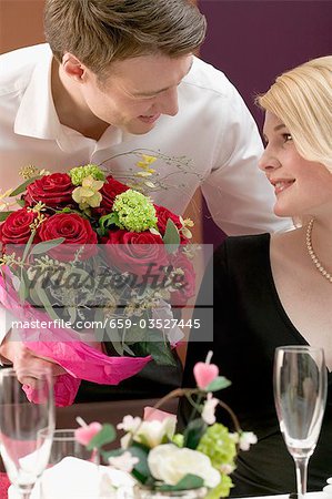 Homme donnant femme un bouquet de fleurs
