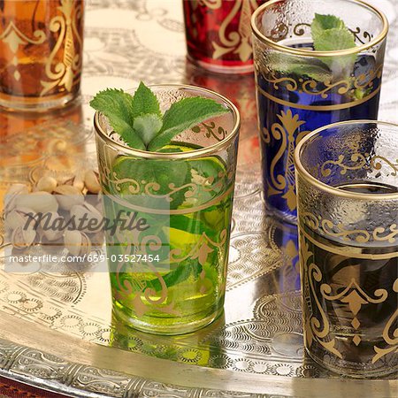 Peppermint tea in Middle Eastern glasses, pistachios Peppermint tea in Middle Eastern glasses, pistachios