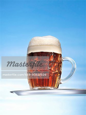 Altbier (top-fermented beer) in glass mug on tray Altbier (top-fermented beer) in glass mug on tray