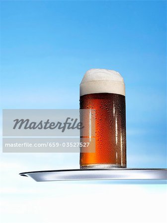 Altbier (top-fermented beer) in glass on tray Altbier (top-fermented beer) in glass on tray