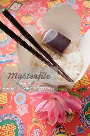 Reis, Sojasauce und Stäbchen in Take-Away-Behälter