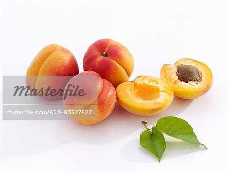 A few apricots with leaves, whole and halved