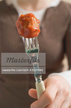 Boulettes de viande sur fourche femme holding