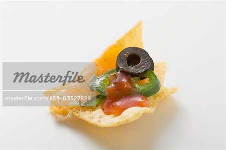 Nacho avec fromage, olives, anneau de piment et ketchup