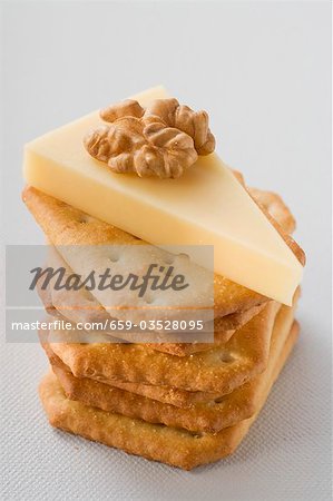 Piece of Emmental cheese with walnut on crackers