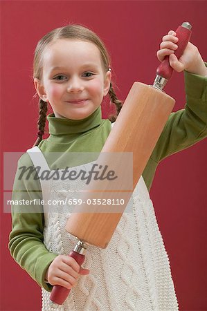 Petite fille holding rouleau à pâtisserie
