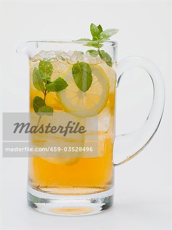 Iced tea with lemon slices and fresh mint in glass jug