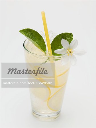 A glass of lemonade with lemon blossom and straw