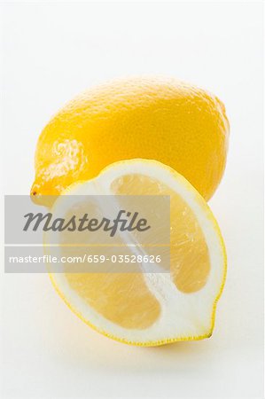 Half a lemon in front of a whole lemon