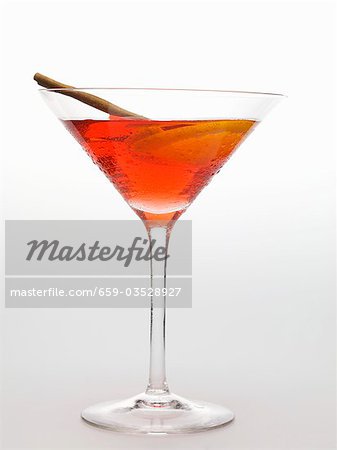Cosmopolitan with cinnamon stick and slice of lemon Cosmopolitan with cinnamon stick and slice of lemon