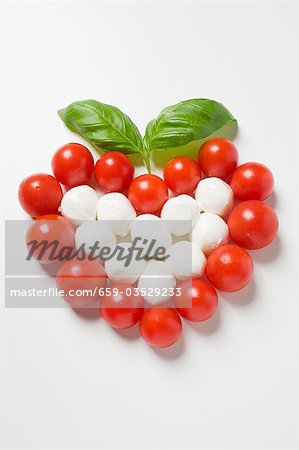 Tomaten und Mozzarella bilden ein Herz mit Basilikum