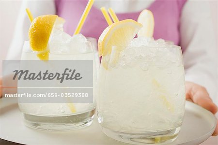 Woman holding a tray of glasses filled with lemonade