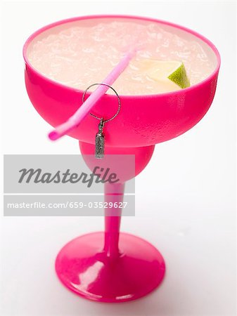 Frozen Margarita with lime wedges in pink glass