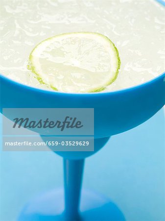 Frozen Margarita avec rondelle de lime en verre bleu Frozen Margarita avec rondelle de lime en verre bleu