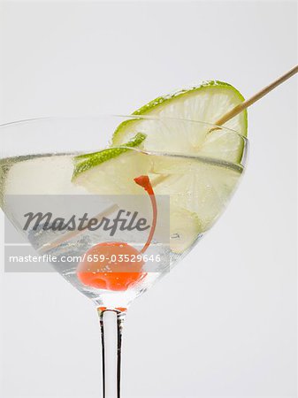 Drink with cocktail cherry and lime Drink with cocktail cherry and lime