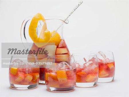 Fruity red wine punch in glass jug and glasses