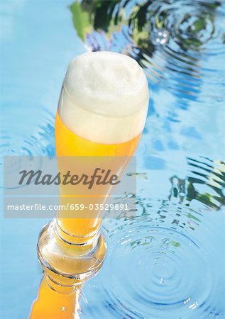Glass of wheat beer on water Glass of wheat beer on water