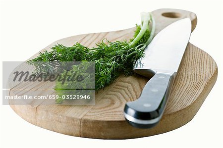 Aneth avec le couteau sur la planche de bois Aneth avec le couteau sur la planche de bois