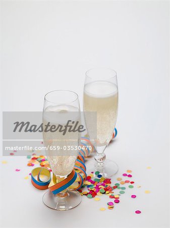 Two glasses of sparkling wine, paper streamer and confetti