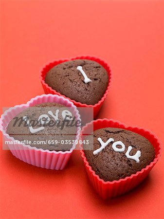 Heart-shaped chocolate muffins for lovers on red background