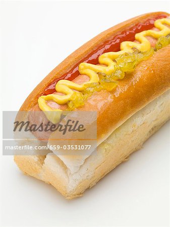 Un Hot-Dog avec la moutarde, le ketchup et cornichon