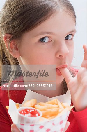 Girl eating chips, licking her thumb
