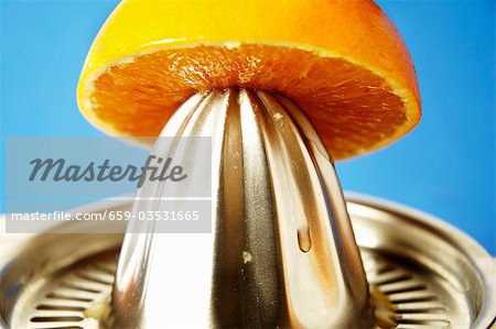 Half an orange on a citrus squeezer