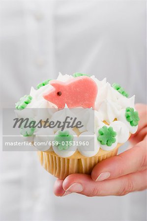 Hand hält Cupcake mit Marzipan Schwein