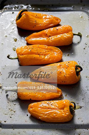 Six yellow peppers on a baking tray