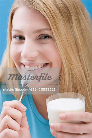 Jeune femme mangeant yaourt nature