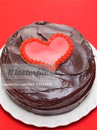 Chocolate cake with red heart-shaped biscuit