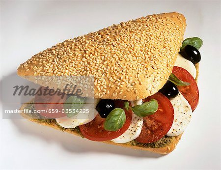 Sesame roll filled with tomato, mozzarella and basil
