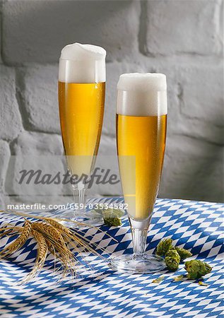 Two glasses of pils on blue and white tablecloth