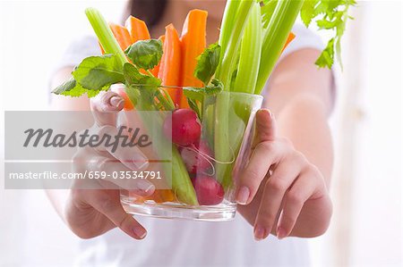 Jeune fille tenant un bol de crudités avec radis