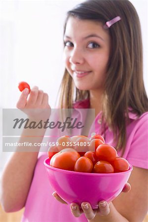 Jeune fille tenant un bol de tomates