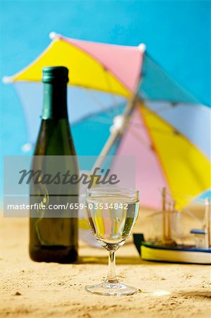 Verre et bouteille de vin blanc dans un décor estival