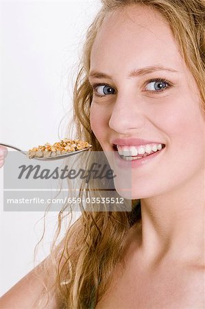 Young woman eating crunchy muesli