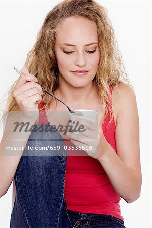 Jeune femme tenant un baquet d'yaourt naturel à la main