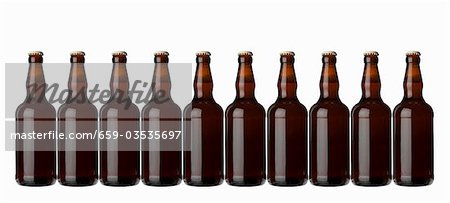 Ten brown bottles standing in a row (lager) Ten brown bottles standing in a row (lager)