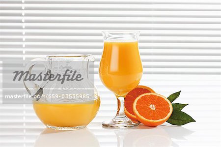 Jus d'orange dans le verre et la verseuse en verre