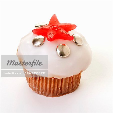 Iced muffin decorated with chocolate beans and jelly sweet