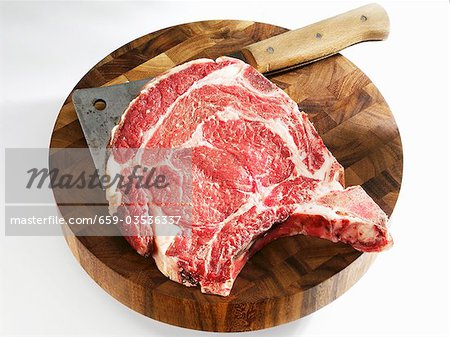 Raw Porterhouse steak with meat cleaver