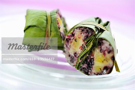 Banana leaves with rice and banana stuffing, cut in two