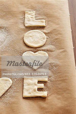 Cut-out 'LOVE' biscuits on baking parchment