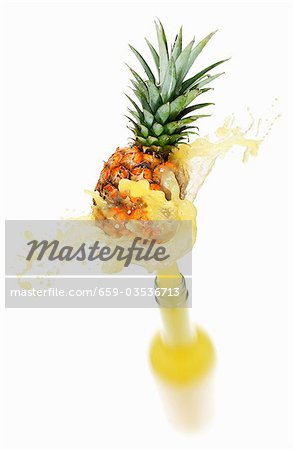 Pineapple juice splashing out of bottle