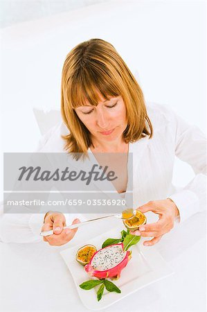 Woman eating passion fruit