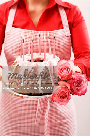 Woman holding ring cake and roses for a birthday